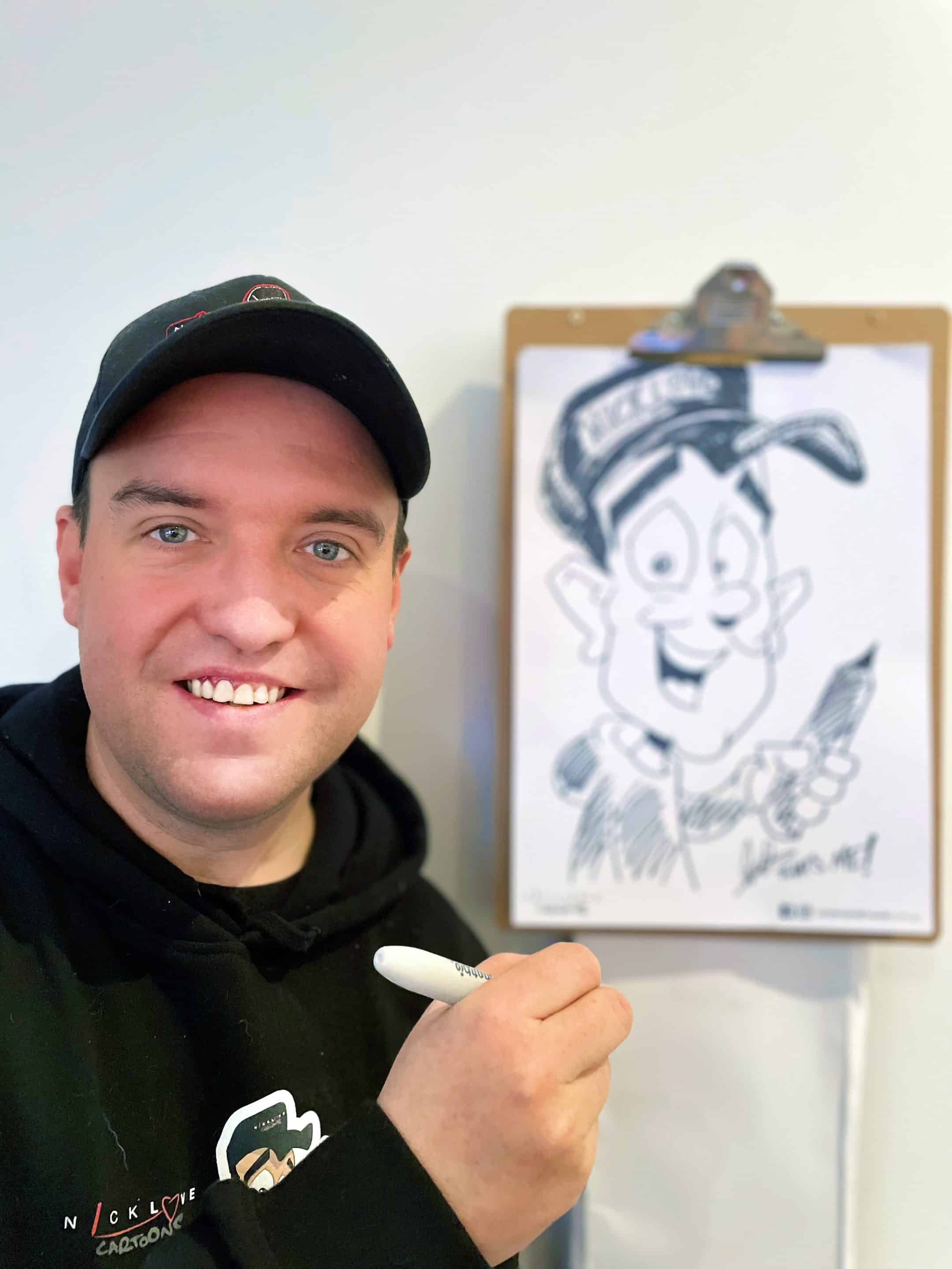 Profile picture of Nick Love smiling while drawing a caricature of himself